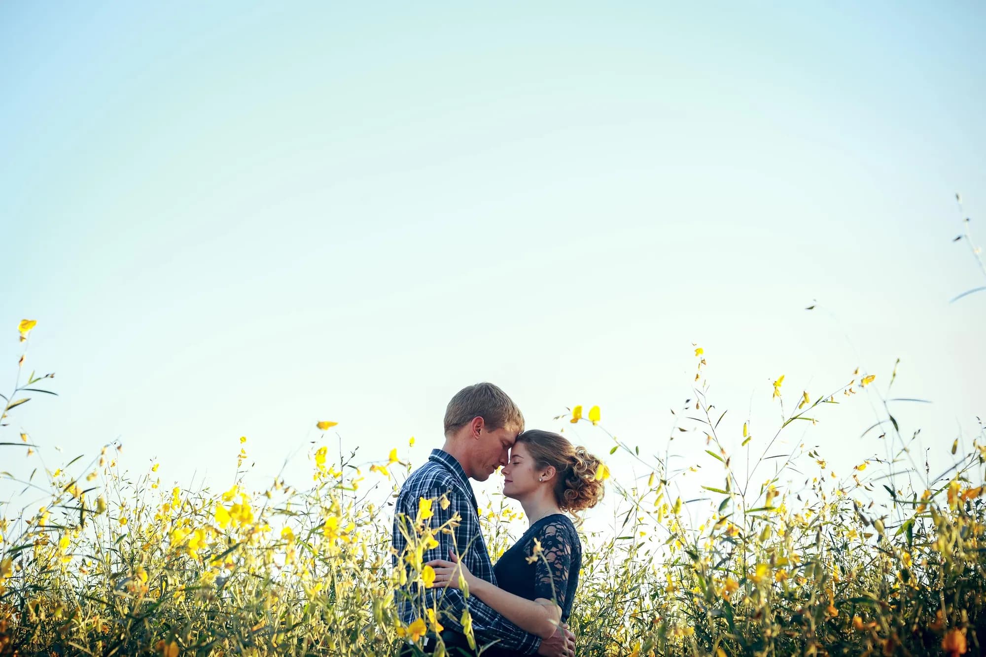 Sesión de pareja en un campo de flores al atardecer