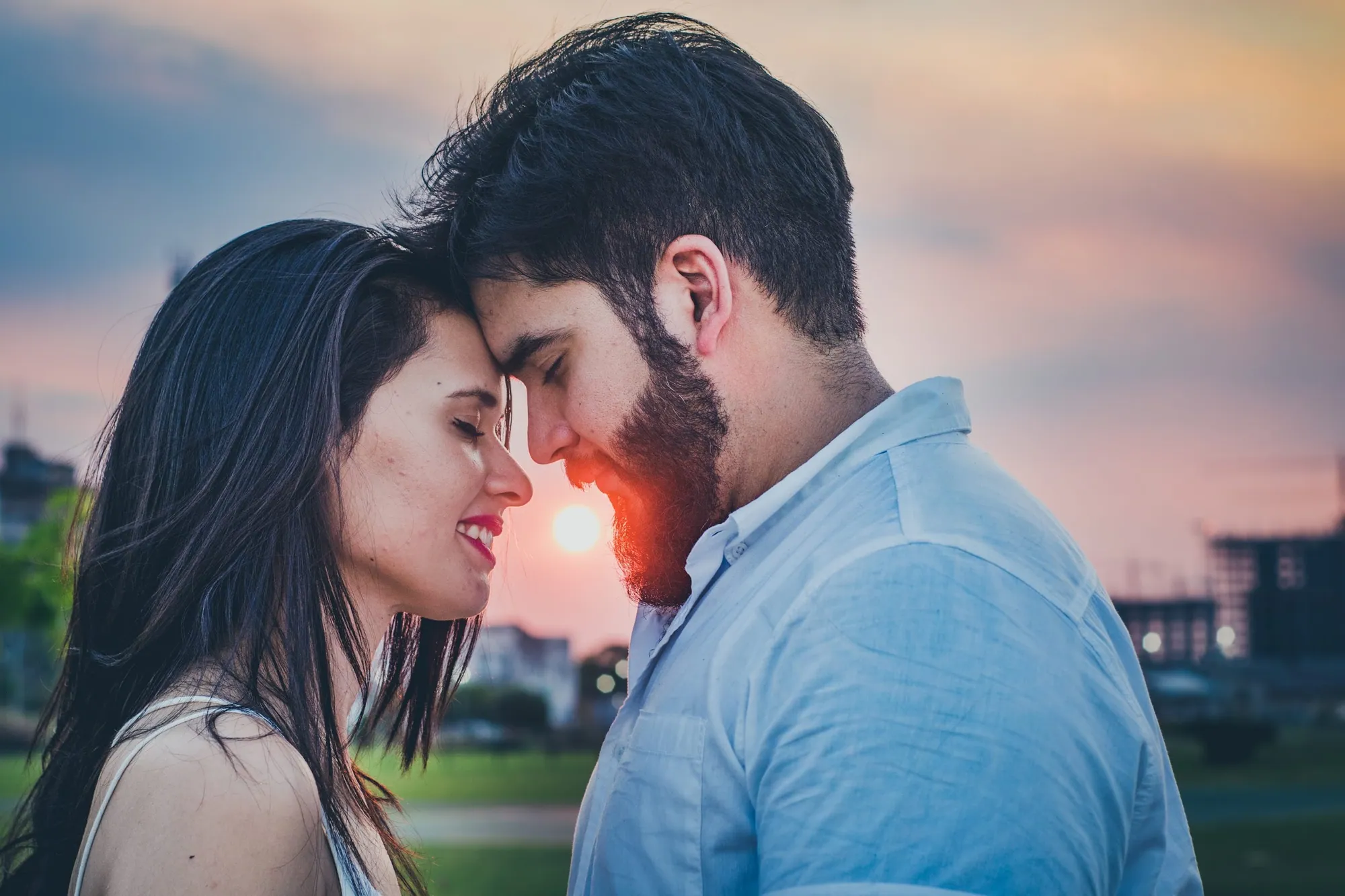 Novios abrazados a contraluz durante el atardecer
